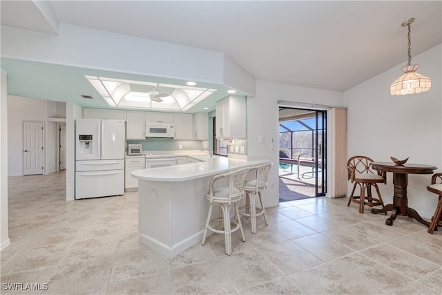 kitchen featuring white cabinetry, sink, kitchen peninsula, pendant lighting, and white appliances