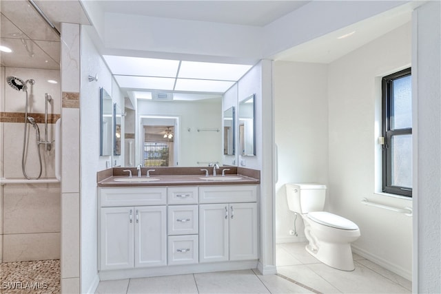 bathroom featuring tiled shower, vanity, tile patterned floors, and toilet