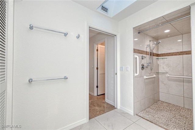 bathroom with tile patterned floors and a tile shower