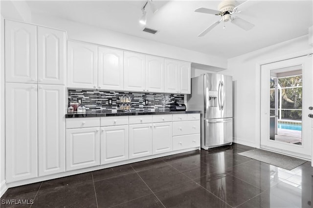 kitchen featuring white cabinetry, ceiling fan, stainless steel fridge with ice dispenser, decorative backsplash, and dark tile patterned flooring