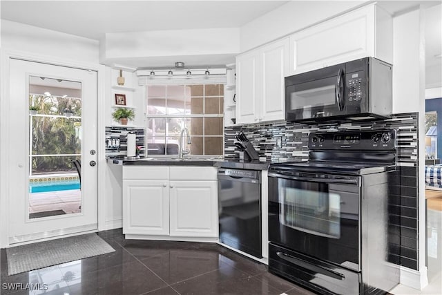 kitchen with black appliances, sink, decorative backsplash, dark tile patterned floors, and white cabinetry