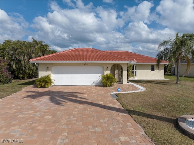 mediterranean / spanish home with a front lawn and a garage