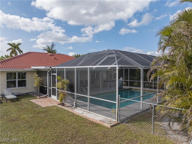 back of property featuring a yard and glass enclosure