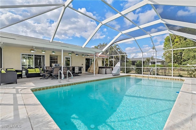 view of pool with outdoor lounge area, a patio, glass enclosure, and ceiling fan