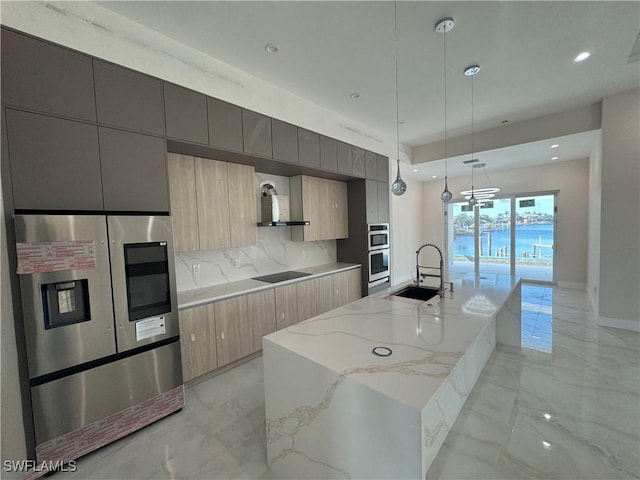 kitchen featuring a large island, modern cabinets, appliances with stainless steel finishes, marble finish floor, and a sink