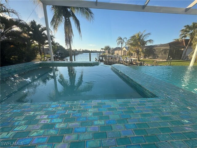 view of swimming pool with a water view and a dock