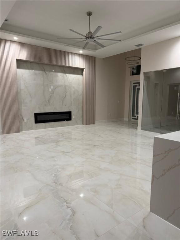 unfurnished living room with marble finish floor, visible vents, a ceiling fan, and a high end fireplace