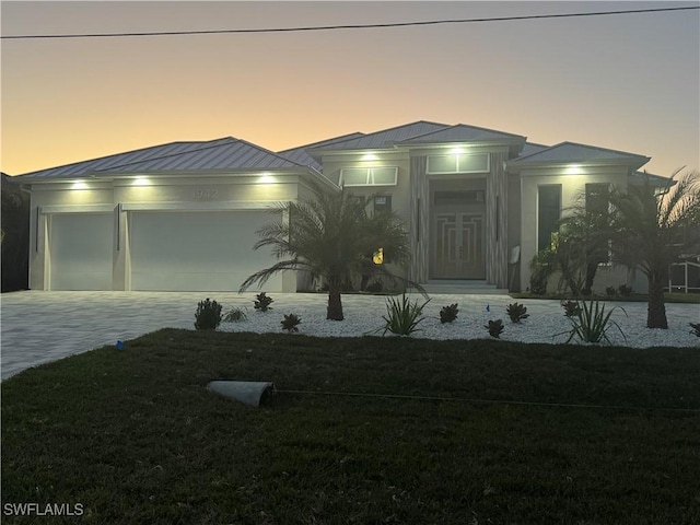 view of front of property featuring a yard and a garage