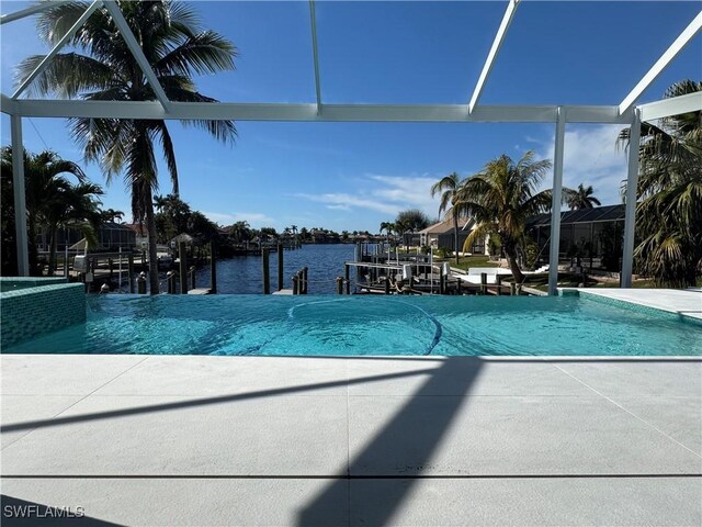 view of pool featuring a water view, a lanai, and a dock