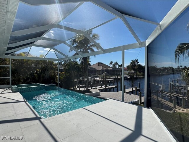 view of pool with a patio area, a boat dock, a water view, glass enclosure, and an in ground hot tub