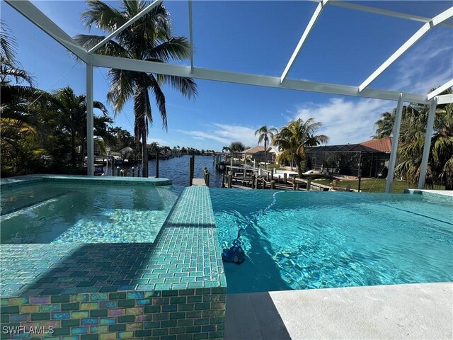 view of swimming pool with glass enclosure and a water view