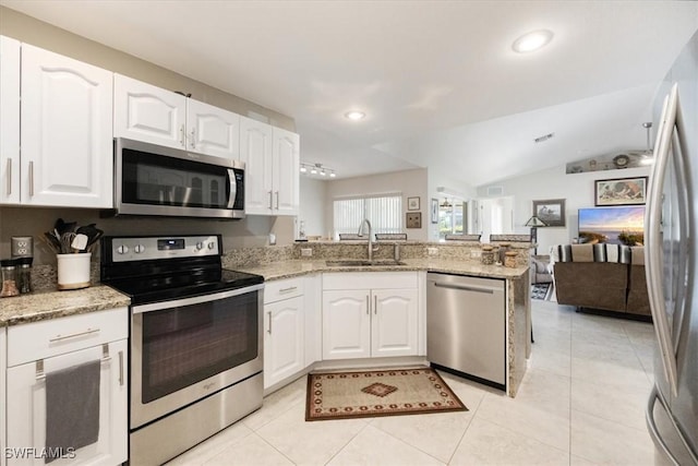 kitchen featuring sink, stainless steel appliances, kitchen peninsula, lofted ceiling, and white cabinets