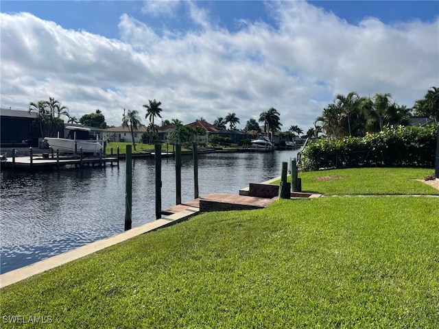 dock area with a yard and a water view