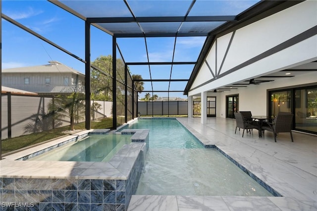 view of swimming pool with ceiling fan, a patio area, glass enclosure, and an in ground hot tub