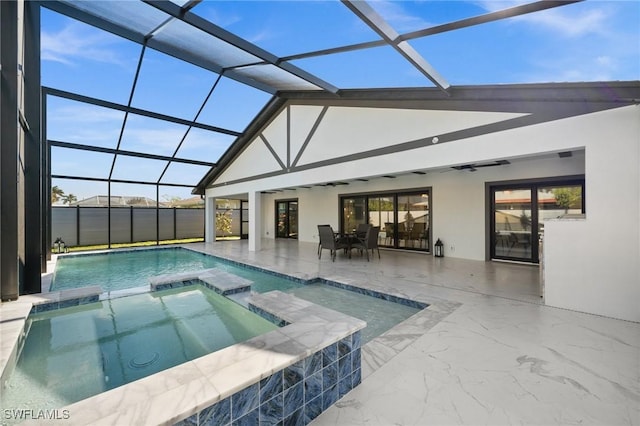 view of pool with a patio area, glass enclosure, and an in ground hot tub