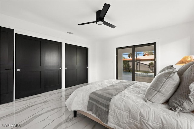 bedroom with two closets, access to outside, and ceiling fan