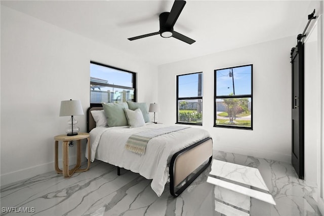 bedroom with a barn door and ceiling fan