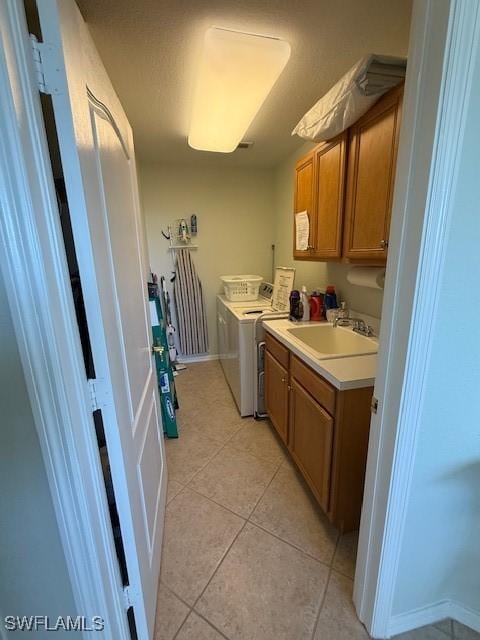 washroom featuring light tile patterned flooring, cabinets, sink, and washing machine and dryer