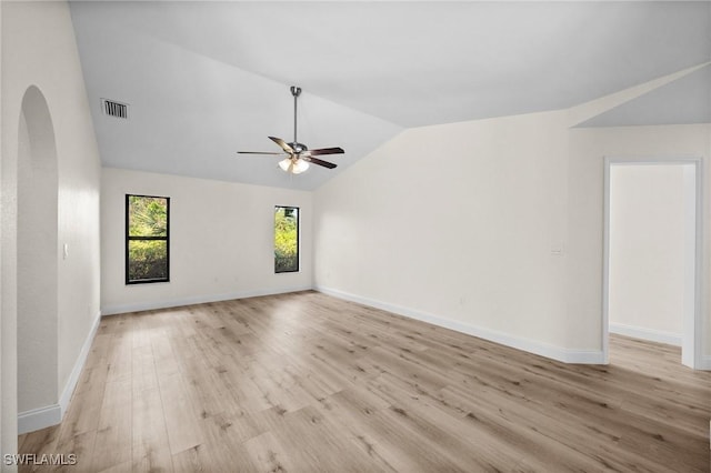 empty room with ceiling fan, lofted ceiling, and light wood-type flooring