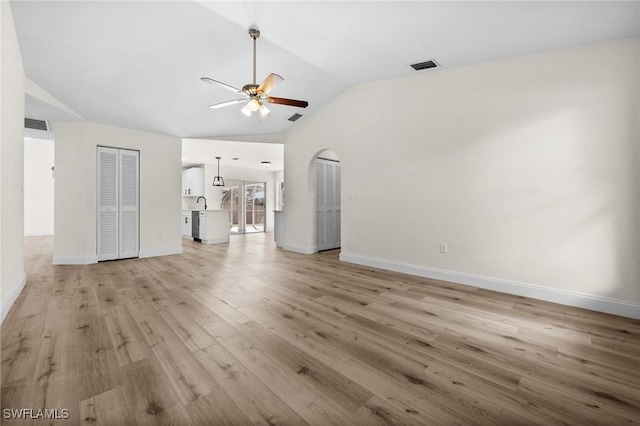 unfurnished living room with light hardwood / wood-style floors, vaulted ceiling, and ceiling fan