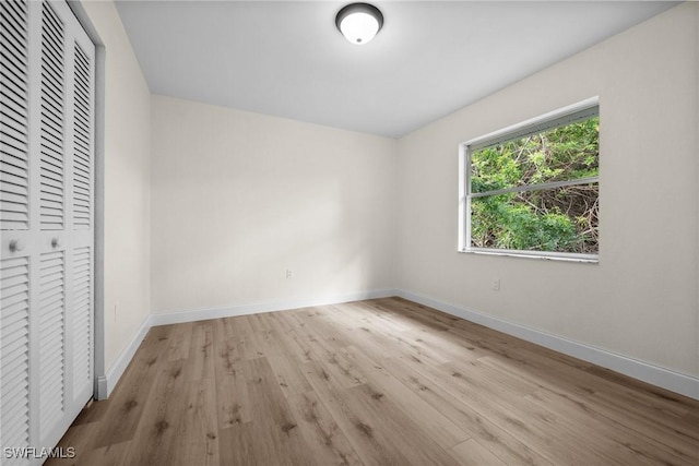 unfurnished bedroom featuring light hardwood / wood-style flooring and a closet