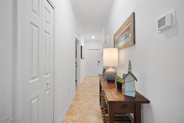 hall featuring light tile patterned floors and crown molding