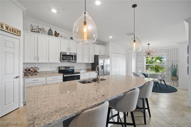 kitchen with appliances with stainless steel finishes, white cabinetry, pendant lighting, and sink