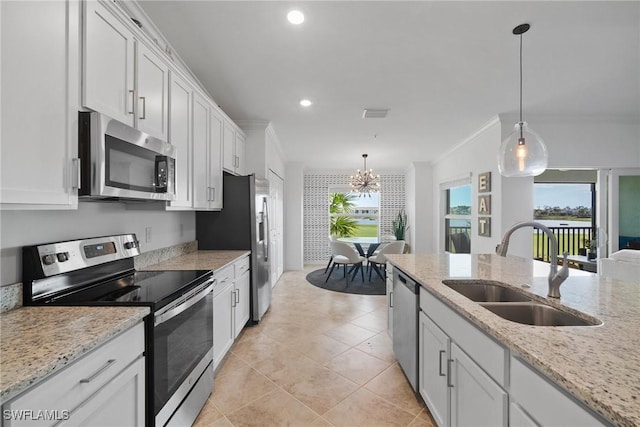 kitchen with light stone countertops, white cabinetry, sink, hanging light fixtures, and appliances with stainless steel finishes