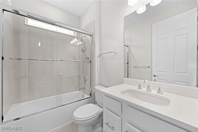 full bathroom featuring tile patterned flooring, vanity, toilet, and bath / shower combo with glass door