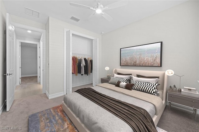 bedroom with ceiling fan, light colored carpet, and a closet