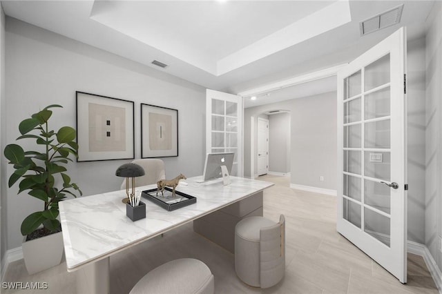 home office with a tray ceiling and french doors