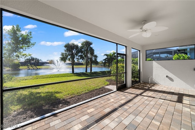 unfurnished sunroom with a water view and ceiling fan