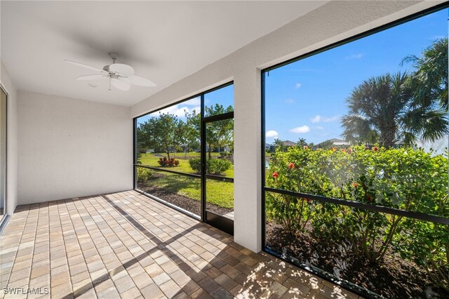 unfurnished sunroom featuring ceiling fan