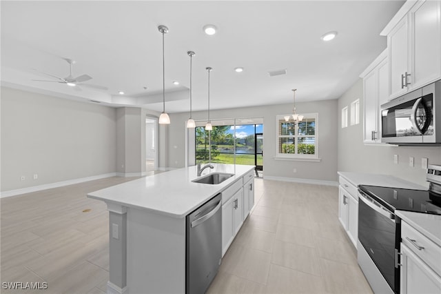 kitchen featuring sink, stainless steel appliances, pendant lighting, a kitchen island with sink, and white cabinets