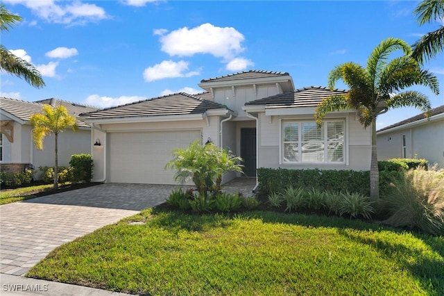 16522 Crescent Beach Way, Bonita Springs, FL 34135 - view of front of home with an attached garage, decorative driveway, a front lawn, stucco siding, and a tile roof