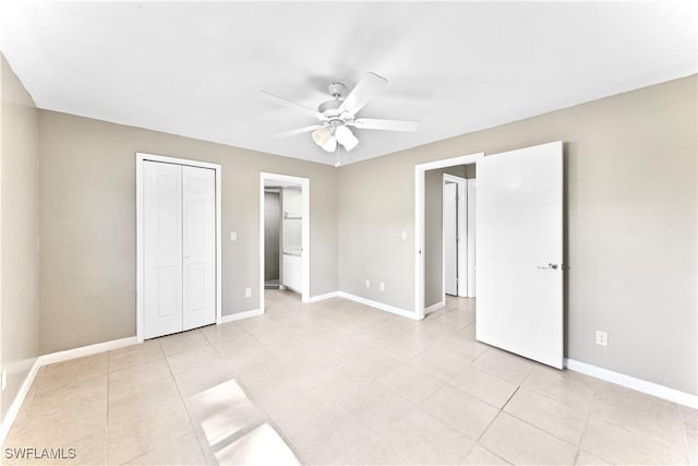 unfurnished bedroom with light tile patterned floors, a closet, ensuite bath, and ceiling fan