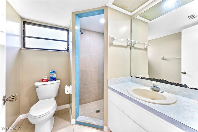 bathroom featuring a tile shower, tile patterned floors, vanity, and toilet