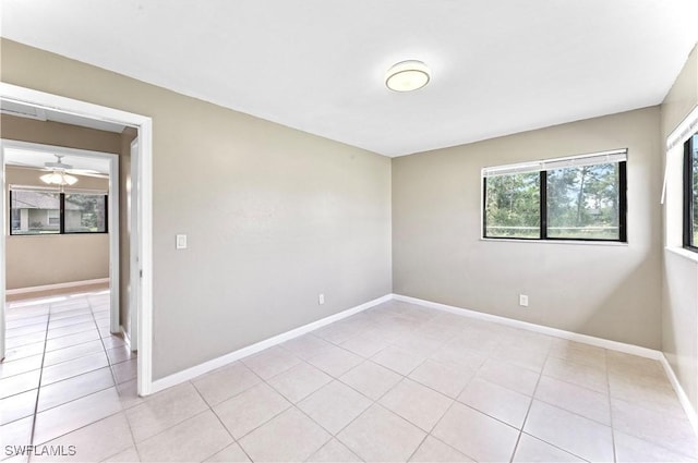 tiled spare room with ceiling fan