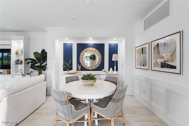 dining room featuring light wood-type flooring and ornamental molding