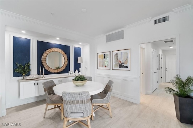 dining space featuring crown molding and light hardwood / wood-style floors