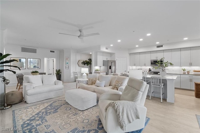 living room with light hardwood / wood-style flooring and ceiling fan