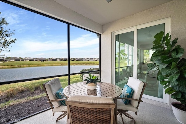 sunroom / solarium featuring a water view