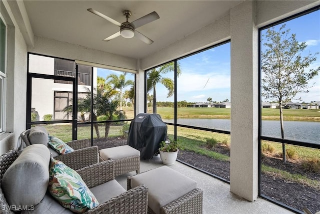 sunroom / solarium featuring a water view and ceiling fan