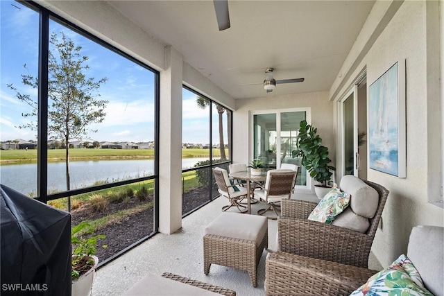 sunroom with a water view and ceiling fan