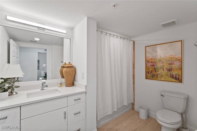 full bathroom with hardwood / wood-style floors, shower / bath combination with curtain, toilet, and vanity