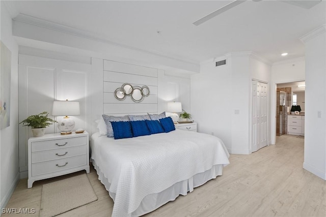 bedroom featuring a closet, crown molding, ceiling fan, and light hardwood / wood-style floors