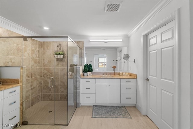 bathroom featuring vanity, an enclosed shower, and crown molding