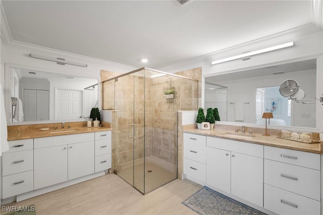 bathroom featuring crown molding, vanity, and an enclosed shower