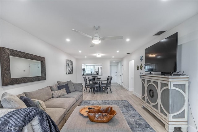 living room featuring light hardwood / wood-style flooring and ceiling fan