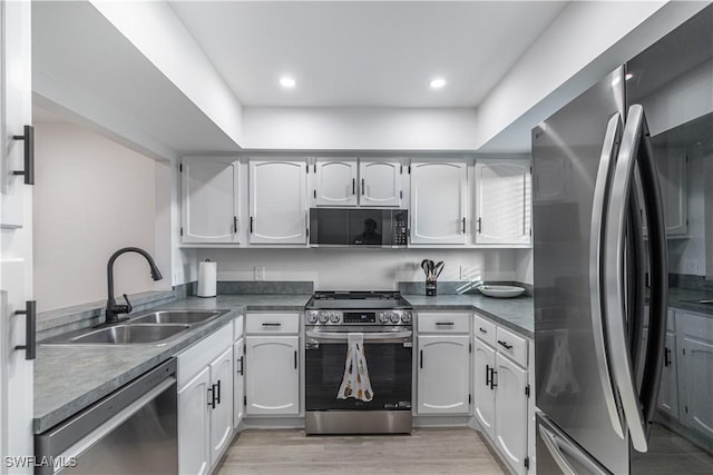 kitchen with light hardwood / wood-style flooring, stainless steel appliances, white cabinetry, and sink